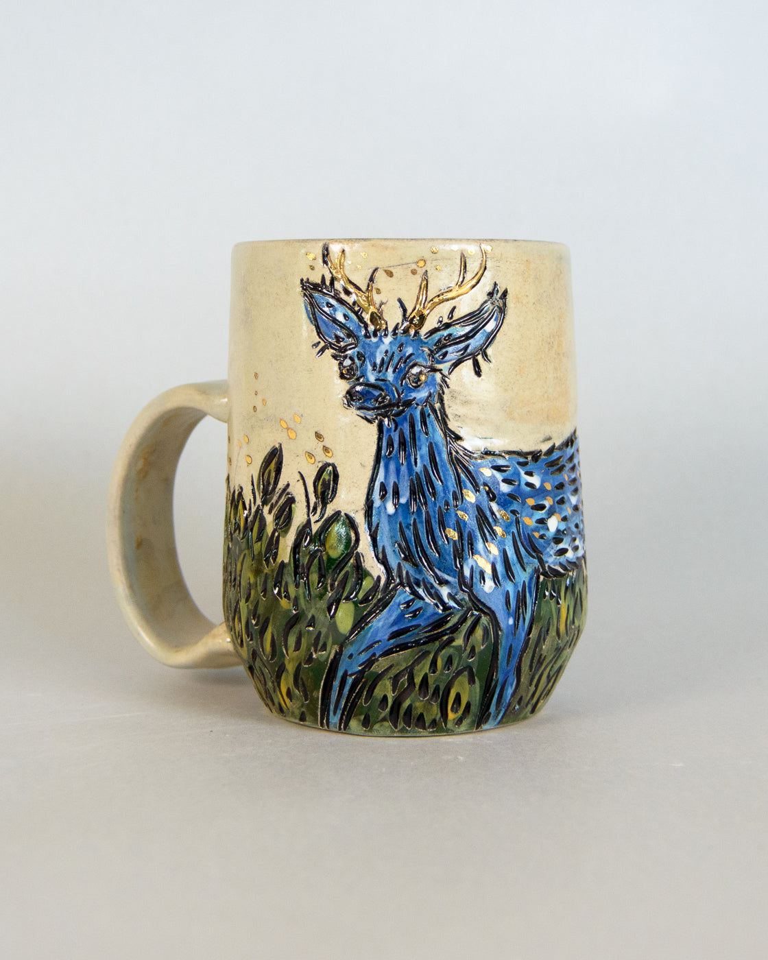 Ceramic mug with a blue deer design on a plain background