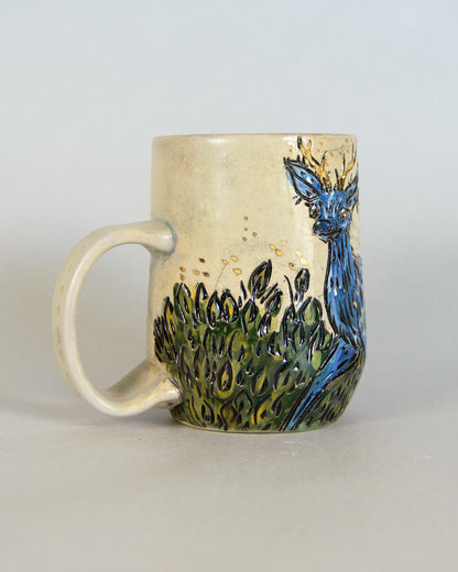 Ceramic mug with a blue deer design on a plain background
