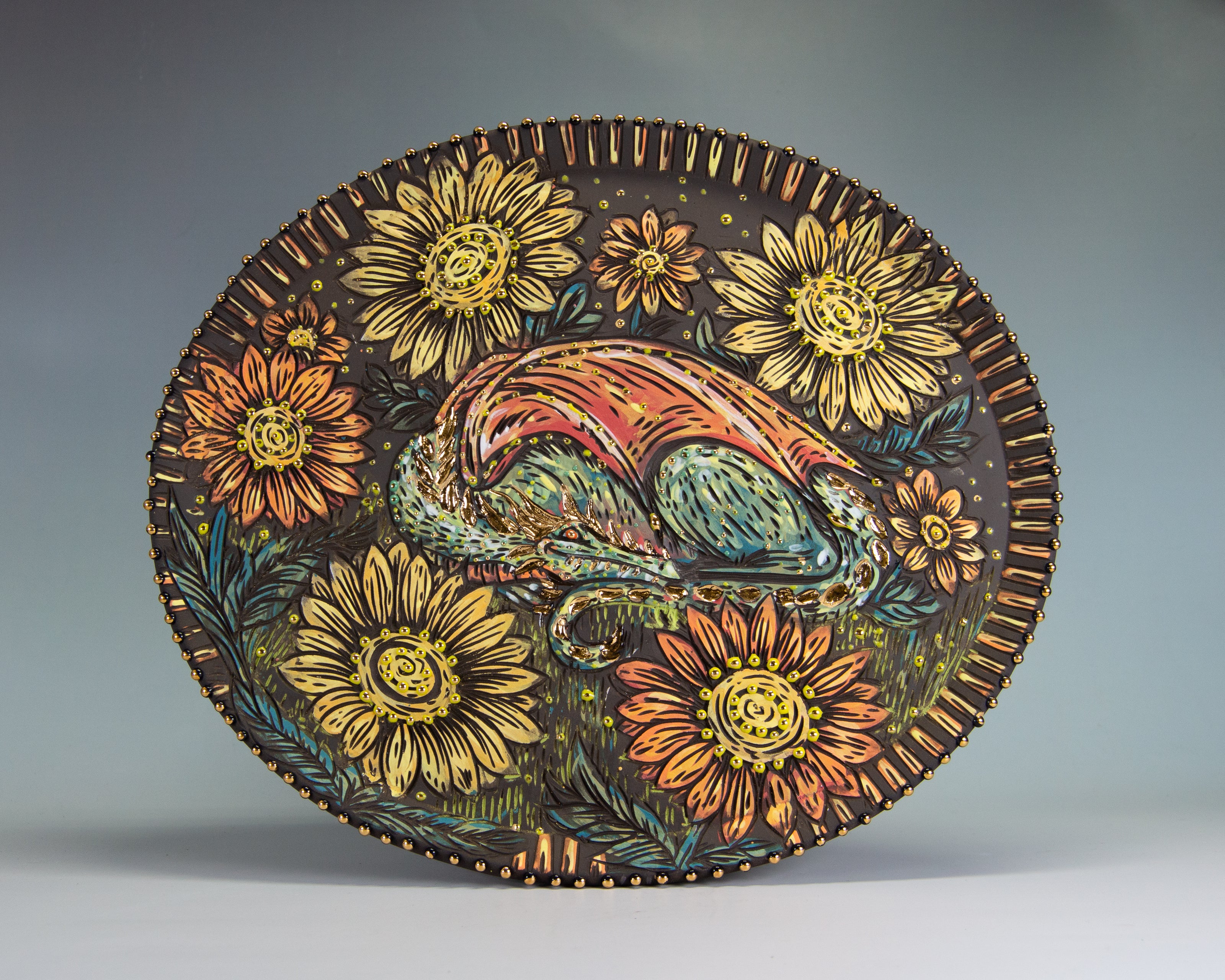 Handmade ceramic decorative platter made with stoneware clay and decorated with a colorful stylized dragon in a field of flowers