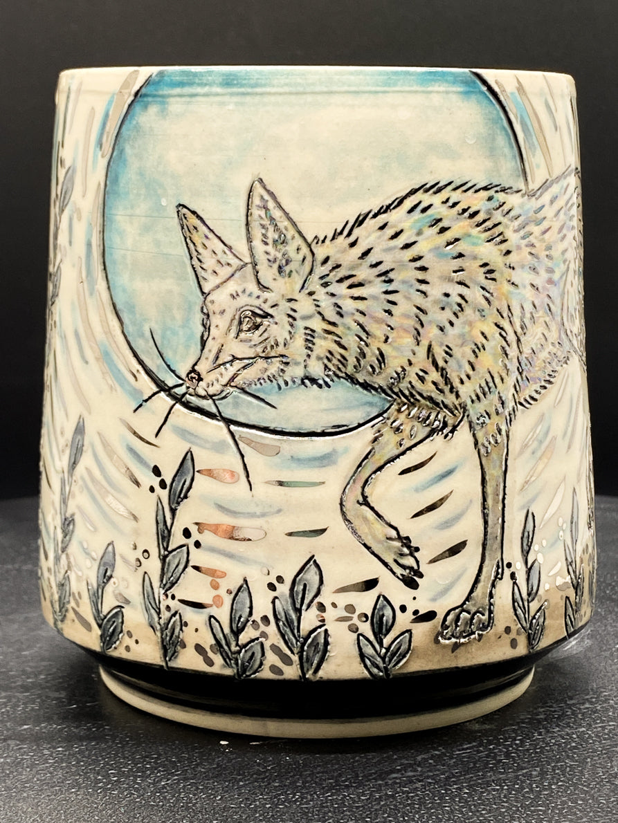 Ceramic mug with a fox design on a black background