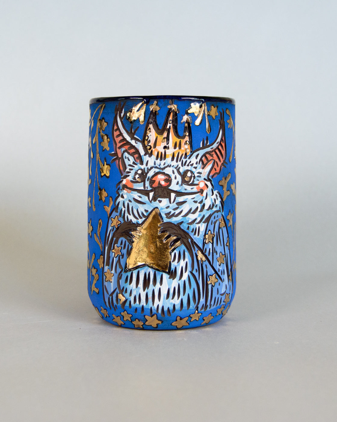 Ceramic mug with a bat and star design on a blue background