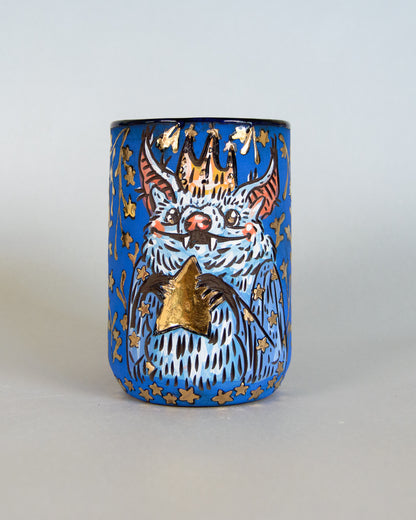 Ceramic mug with a bat and star design on a blue background