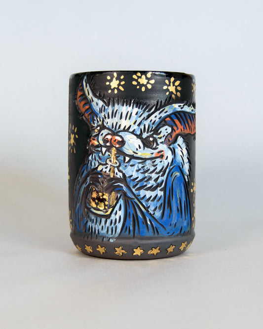 Ceramic mug with a colorful cute bat design and gold stars
