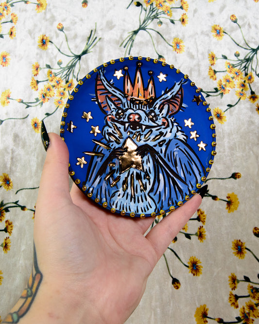 Colorful ceramic coaster with a cute cartoon design of a bat wearing a crown and holding gold shiny stars