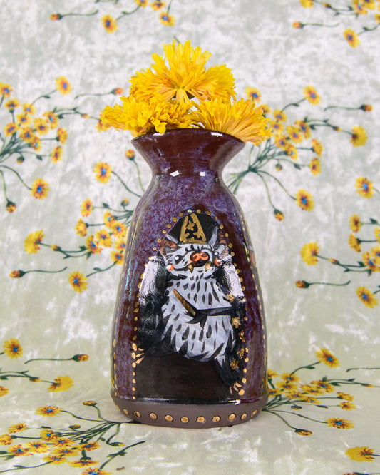 Decorative stoneware vase with a painted design of a wizard bat on a floral background