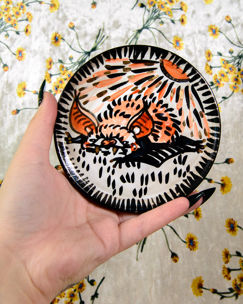 ceramic coaster with a painted sunburnt bat design