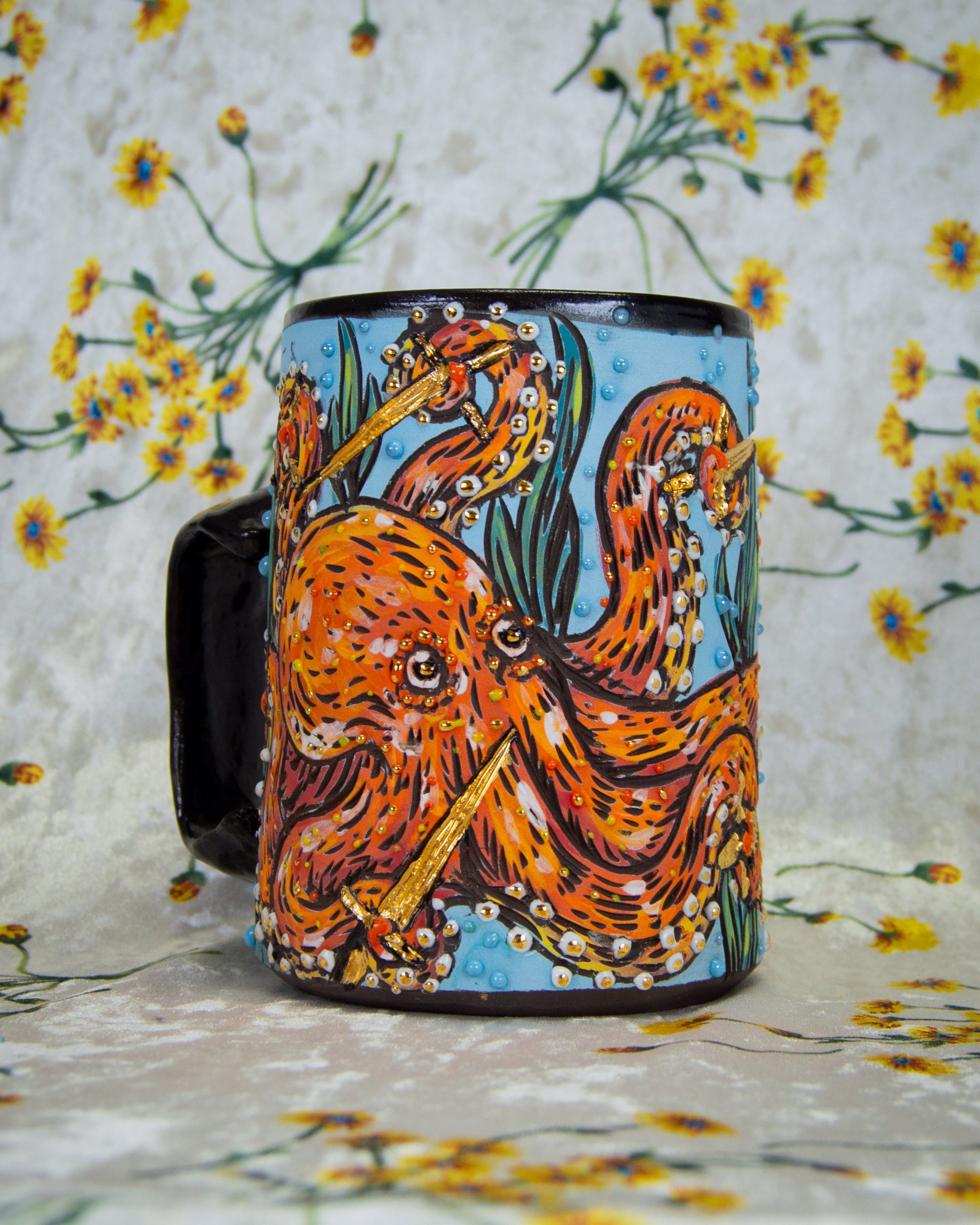 Colorful handmade mug with an octopus fighting with golden swords design on a floral background