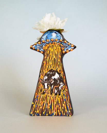 Decorative vase with artistic design of an alien spaceship and cow on a light gray background