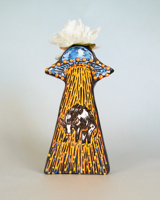 Decorative vase with artistic design of an alien spaceship and cow on a light gray background