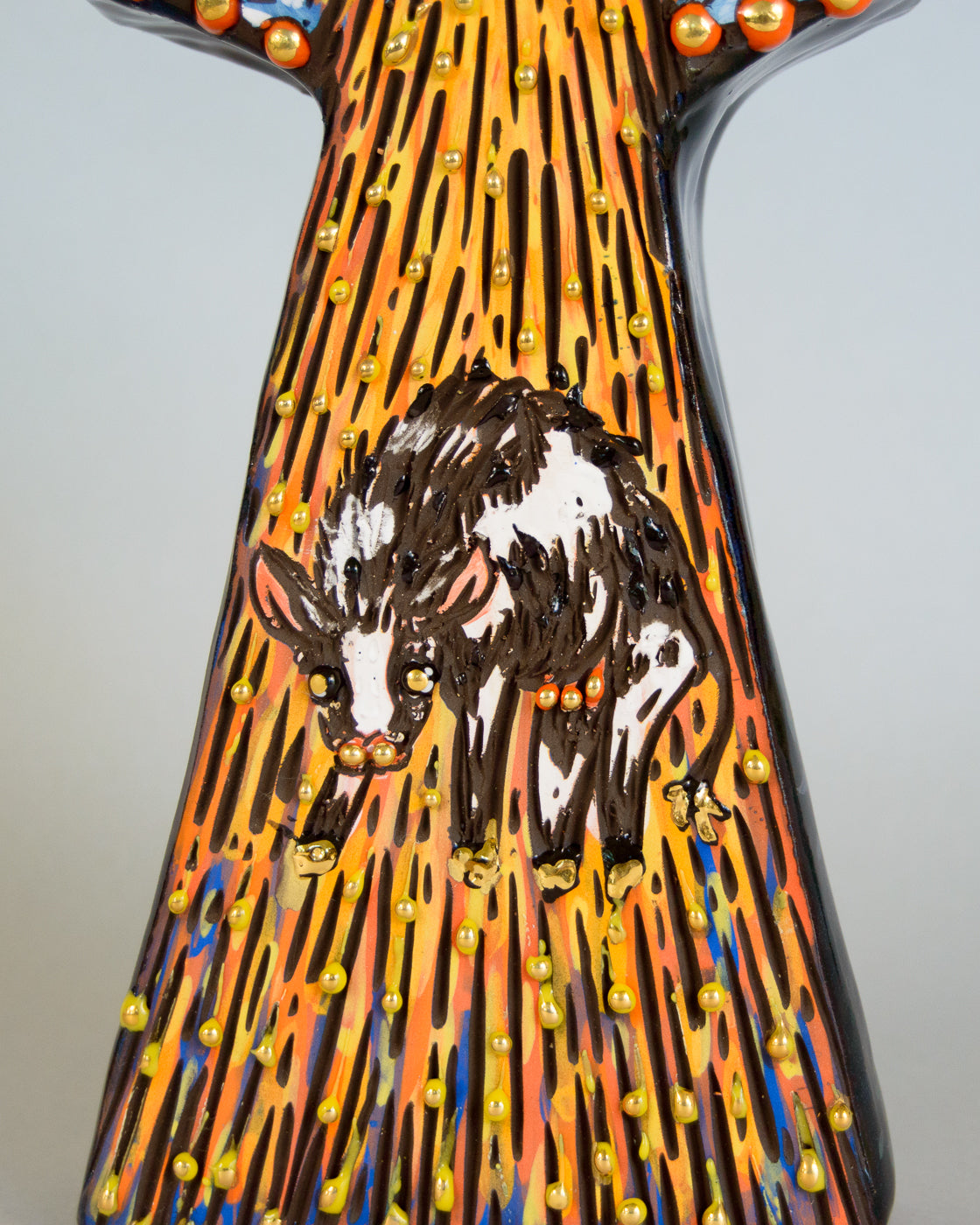 Decorative vase with a design of a cow on a colorful background