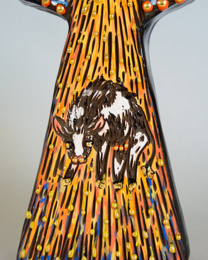 Decorative vase with a design of a cow on a colorful background