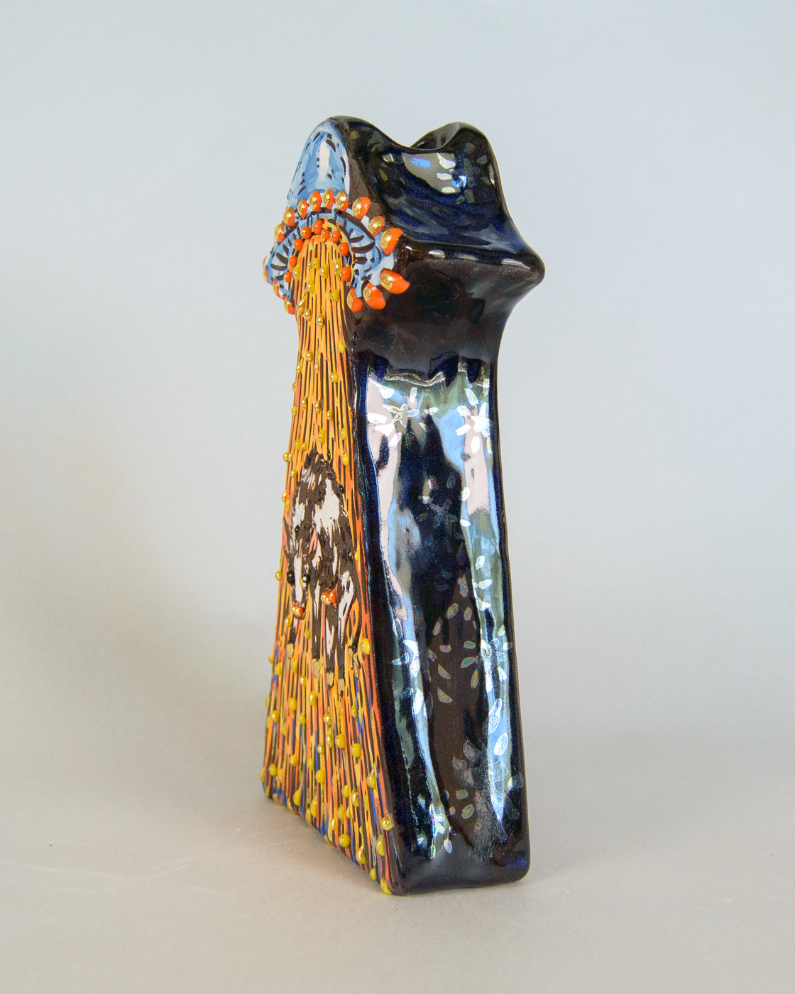 Decorative vase with artistic UFO design on a plain background