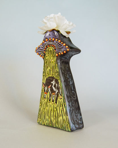 Decorative vase with artistic design and white flower on a light gray background