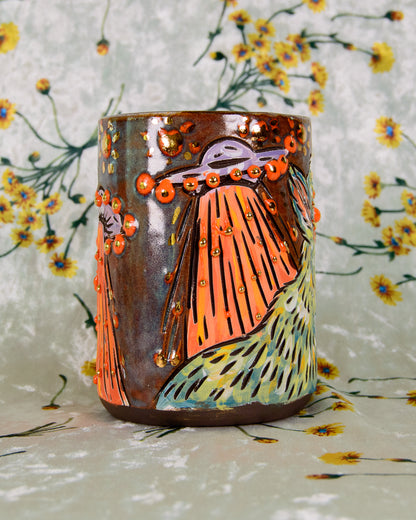 Decorative ceramic cup with artistic design on a floral background
