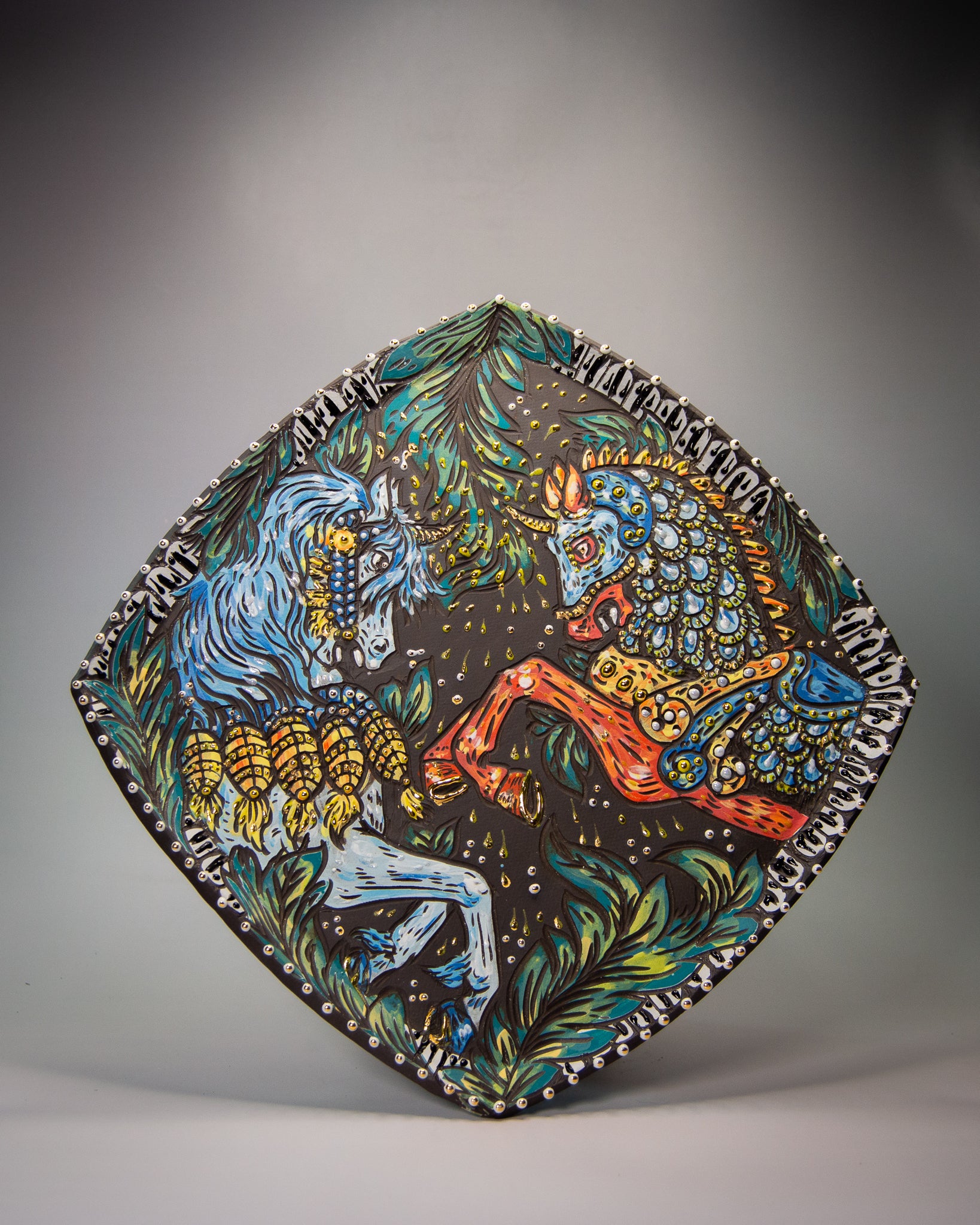 Handmade decorative ceramic stoneware platter with dueling unicorn and leaf designs