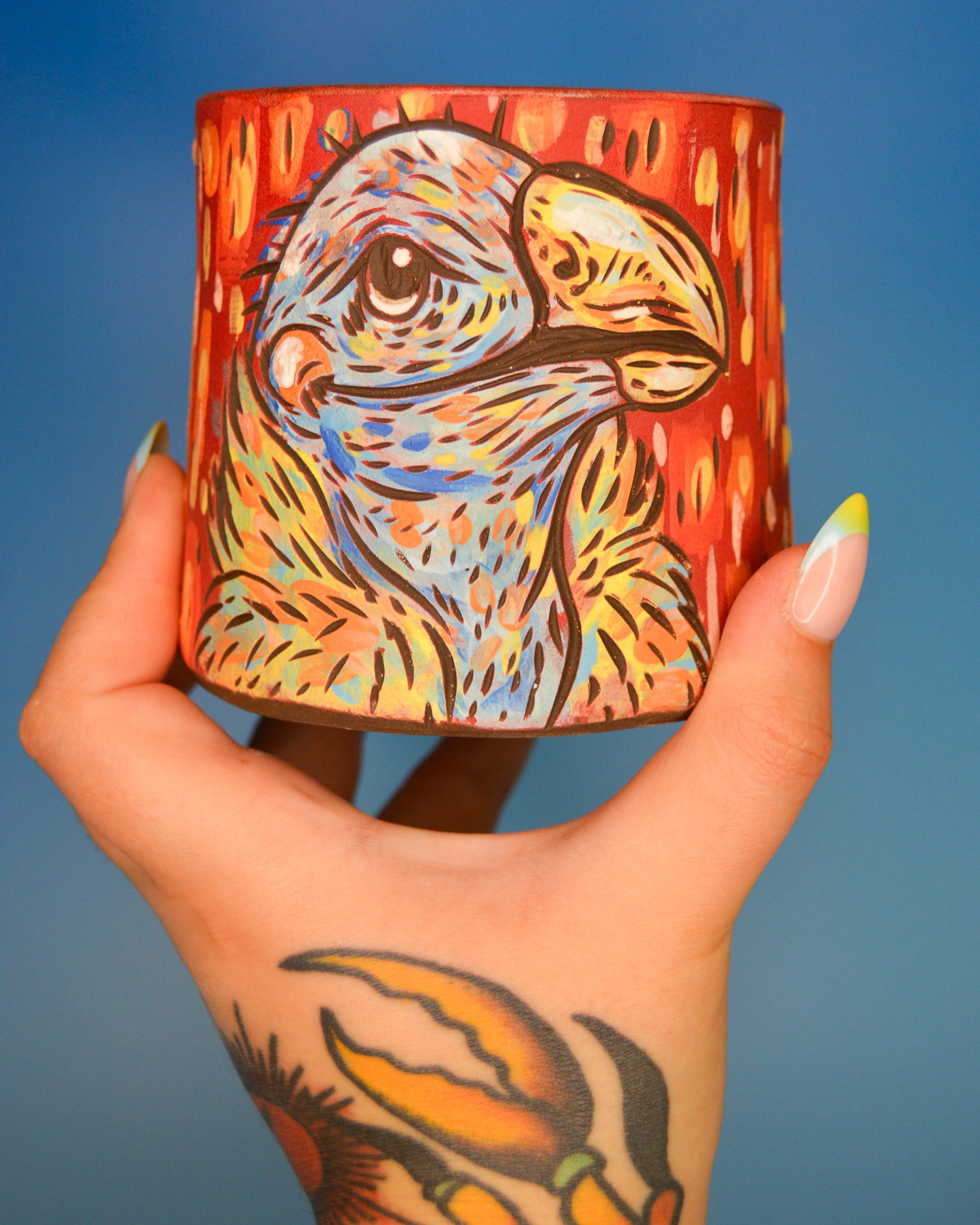 Handmade ceramic stoneware planter with a stylized red and blue vulture design
