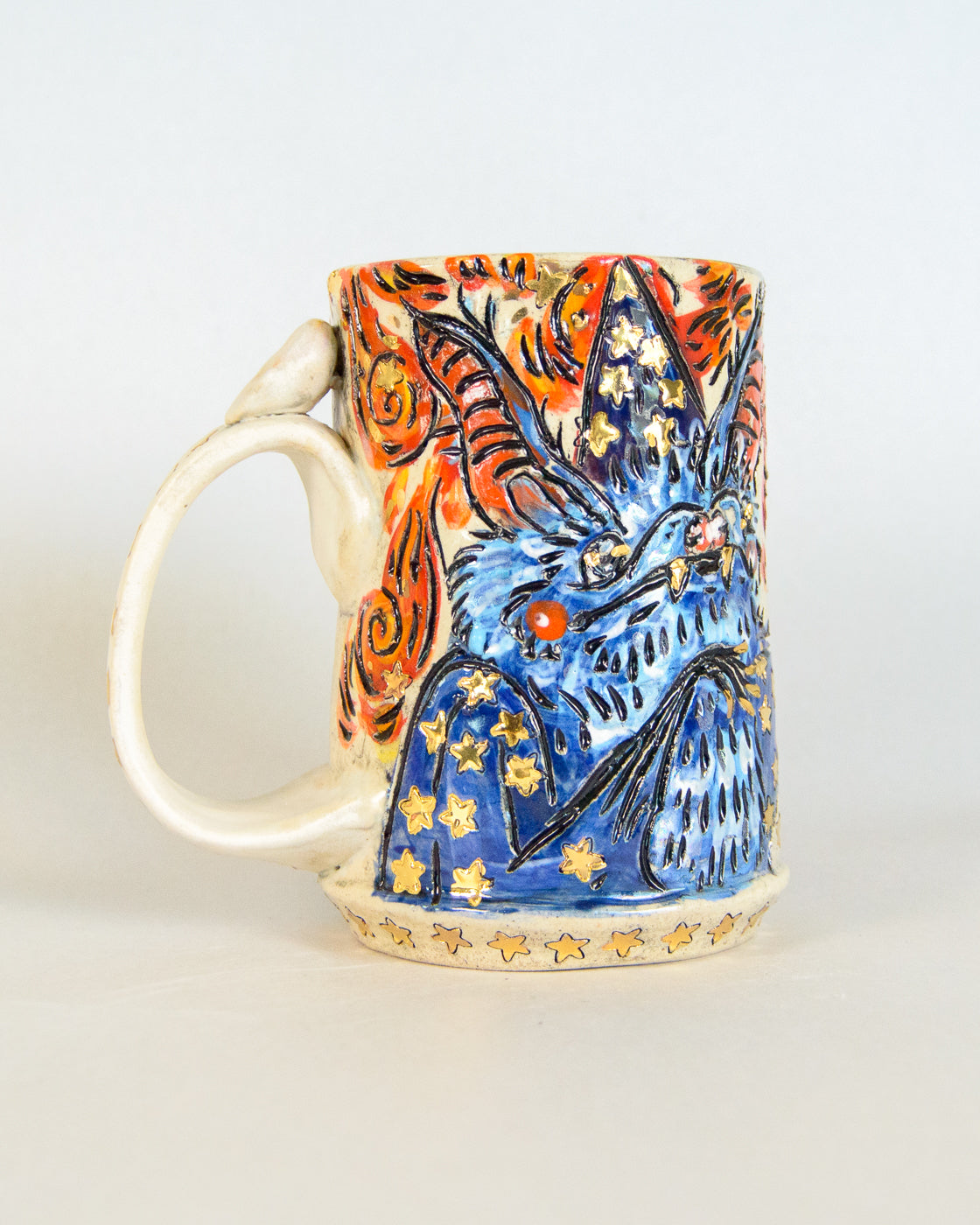 Ceramic mug with a colorful design of a wizard bat and stars on a white background