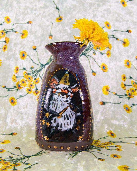 Decorative stoneware vase with a painted design of a wizard bat on a floral background