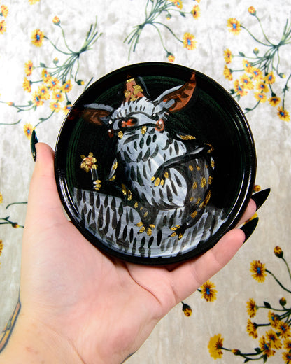 hand painted ceramic coaster with a cartoon bat wizard holding a flower