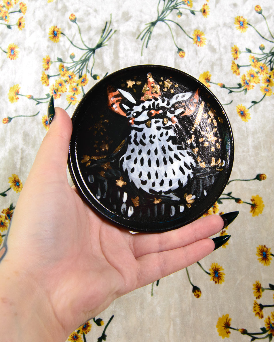 round ceramic coaster with a cartoon bat wizard design and gold details